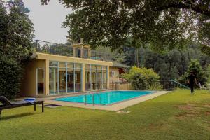 a man walking in front of a house with a swimming pool at The View Residence in Kandy