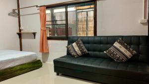 ein Wohnzimmer mit einer grünen Couch und einem Fenster in der Unterkunft Pakham hostel in Pai
