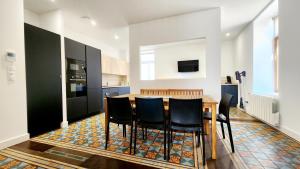 a kitchen with a wooden table and black cabinets at Le Jardin d'Eden in Ay-sur-Moselle +21 photos