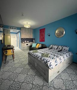 a bedroom with a bed and a blue wall at Bamboo Beach Tsikhisdziri Seaview Flat 838 in Tsikhisdziri