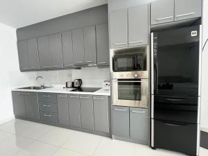 a kitchen with stainless steel appliances and gray cabinets at Viewtalay Beachfront by ND in Pattaya South