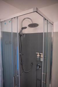 a shower with a glass door in a bathroom at Cozy Historical Nest in Naples