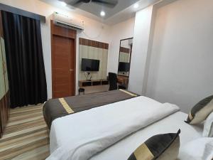 a hotel room with two beds and a desk at Celestial Inn in Prayagraj