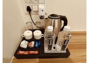 a coffee maker with bottles of water and toothpaste at Celestial Inn in Prayagraj +22 photos