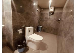 a bathroom with a white toilet in a room at Celestial Inn in Prayagraj