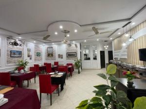 a restaurant with red chairs and tables in a room at Hotel Tulip Inn, Gulberg in Lahore +37 photos