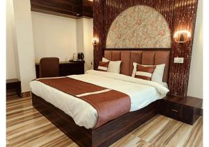 a bedroom with a large bed and a desk at Celestial Inn in Prayagraj