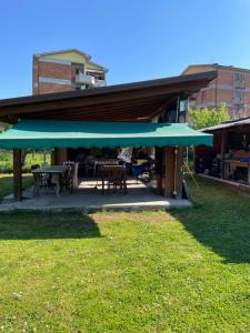 un patio con mesa, sillas y sombrilla azul en La Perla Marina, en Marina di Massa