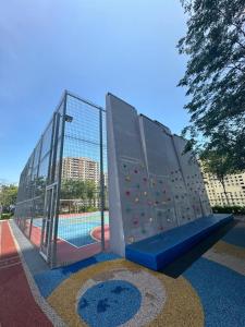 a playground with a climbing wall next to a pool at Georgetown Ins Cozy Suites 2BR in George Town
