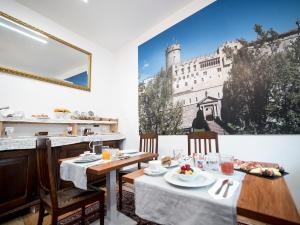 a dining room with a table and a picture of a building at B&B La Loggia Del Castello in Trento