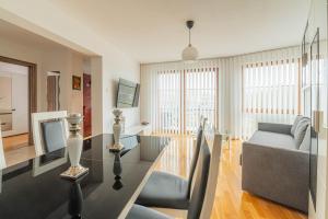 a living room with a glass table and a couch at Horyzont Apartamenty- Apartament Nadmorski, blisko PKP i centrum in Kołobrzeg