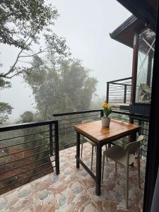 a wooden table and a chair on a balcony at Aesthetic Chalet- 1 Loft Bedroom in Baguio