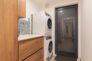 a washer and dryer in a bathroom with a sink at Majestic Waters in Queenstown