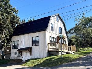 una casa blanca con techo negro en The Harbour House Montague, en Montague