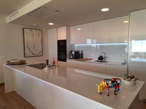 eine weiße Küche mit einer Spielzeugkühe auf der Theke in der Unterkunft Malavamos One Heights Mijas in Mijas Costa + 27 Fotos