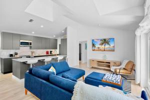 a living room with blue couches and a kitchen at Little Pink Houses in Anna Maria