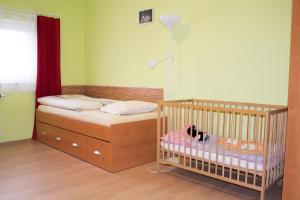 a small bedroom with a crib and a lamp at Penzion Veritas in Vranovice