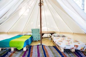 Tienda de campaña con 2 camas y silla en una habitación en La Casa Nel Bosco - Natura & Relax, en Eclause