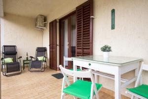 a table and chairs on the patio of a house at Home Away From Home with a heated pool in Punat