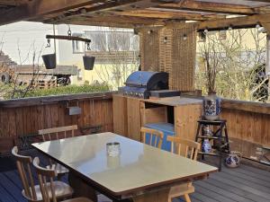 a patio with a table and a grill on a deck at Ferienwohnung Ilka's Lodge in Michelstadt