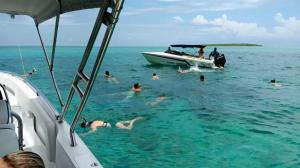 un grupo de personas en el agua cerca de un barco en Sunny Boat Tours, en Trou d'Eau Douce