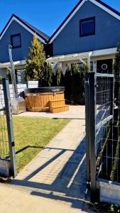 una recinzione davanti a una casa con vasca idromassaggio di FLAUTA Całoroczne domki z prywatną balią, sauną i jacuzzi a Sianozety