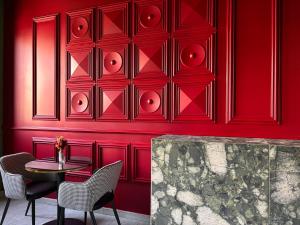 米兰AV Hotel Milano的一间拥有红色墙壁和桌椅的用餐室