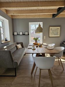 a living room with a table and a couch at Ferienhaus Mühle 5 in Krummhörn