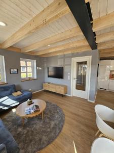 a living room with a blue couch and a tv at Ferienhaus Mühle 5 in Krummhörn