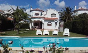 a villa with a swimming pool in front of a house at Villa ANATMA in Les tres Cales
