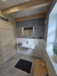 a bathroom with a sink and a mirror at Ferienhaus Mühle 5 in Krummhörn +22 photos