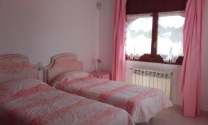 two beds in a bedroom with pink curtains and a window at Villa ANATMA in Les tres Cales +23 photos