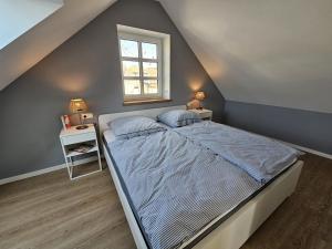 a bedroom with a bed and a window at Ferienhaus Mühle 5 in Krummhörn