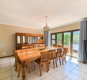 a dining room with a wooden table and chairs at Randall House in Gonubie