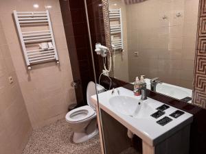 a bathroom with a sink and a toilet and a mirror at Two Lions Hotel in Tbilisi City
