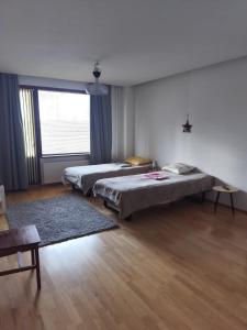 two beds in a room with a large window at LibO-apartment, Rypys 74 X in Kuopio +20 photos