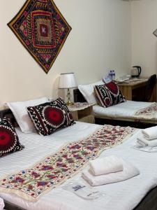 two beds with pillows and a blanket on them at Art Suzani National House Hotel in Bukhara