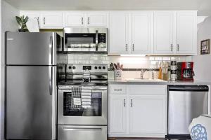 Una cocina con gabinetes blancos y un refrigerador de acero inoxidable. en Fall Creek 58-8, Pet Friendly, Great Location, en Branson
