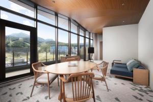 a room with a table and chairs and a bed at Nikko Style Niseko HANAZONO in Kutchan