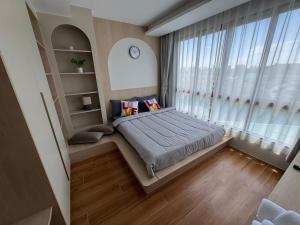 ein Schlafzimmer mit einem Bett und einem großen Fenster in der Unterkunft Fantasea Kamala 1 BR Near Fantasea Show & Beach 505 in Phuket + 57 Fotos