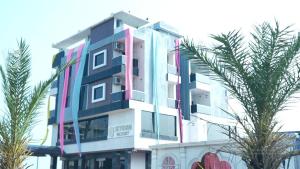 a tall building with palm trees in front of it at Skyfarm Resort in Barāgaon