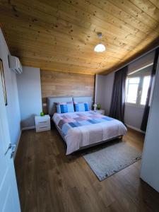 都拉斯Albanian Traditions Legacy的卧室里有一张大床，配有木质天花板 更多11张照片