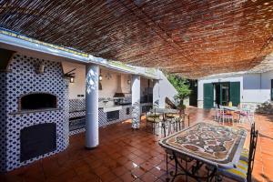an outdoor patio with a fireplace and tables and chairs at Villa Margherita Amalfi Coast in Vietri sul Mare