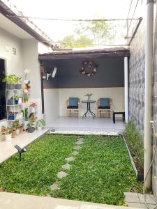 un patio con mesa, sillas y césped en Entire Home in West Lombok near Senggigi, en Montongbuwoh