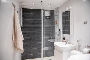 a bathroom with a shower and a toilet and a sink at City Center Bright 2-rooms Scandinavian apartment in Helsinki