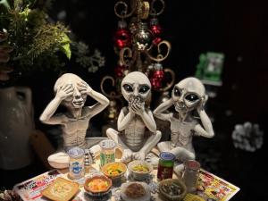 three skeleton figurines sitting on a table with food at HOTEL AMARIS & HIP (Adult Only) in Kanazawa