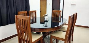 a dining room table with chairs and a glass vase on it at Diya Homestay Mamalakandam in Mamalakandam +10 photos