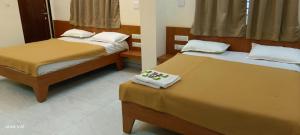 索姆纳特Hotel Tulsi的宿舍间的两张床,床上配有毛巾