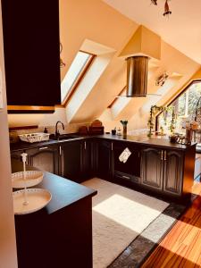 a kitchen with black cabinets and a skylight at Spa Residence Családi Wellness Apartman in Veszprémfajsz