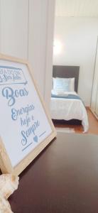 a sign on a table in a bedroom with a bed at Bonança Dunas Village in Fão